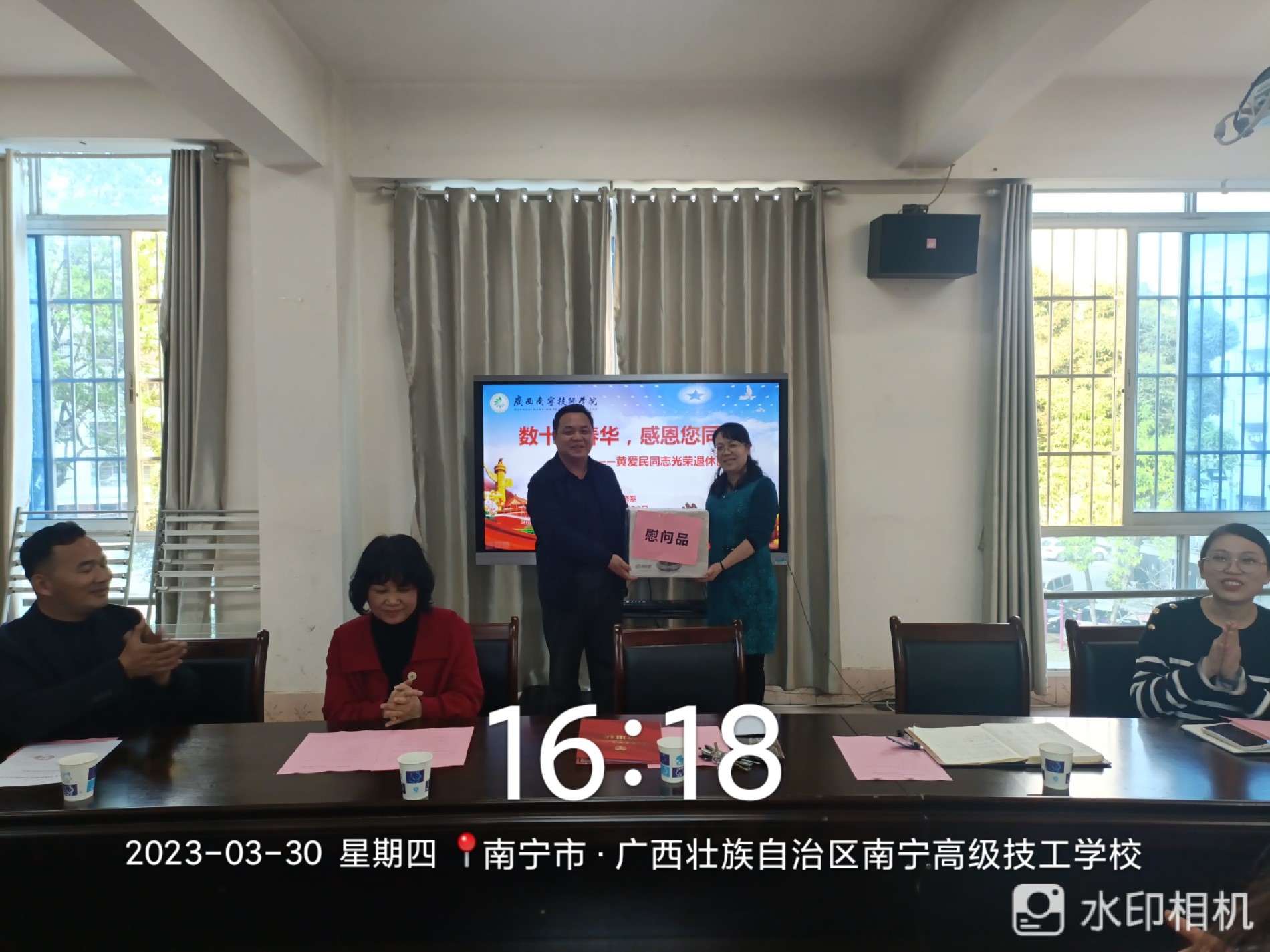 工会副主席李经炎为黄爱民老师颁发退休慰问品.jpg